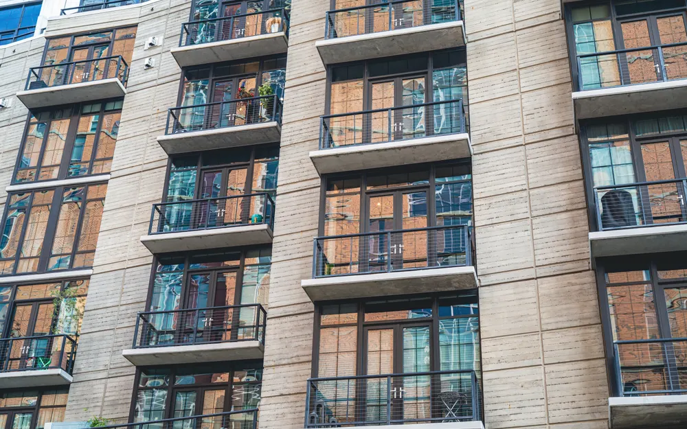Beton fasadlı və şüşələnmiş balkonlu yaşayış binası